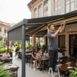 Engineered commercial awning sheltering an alfresco restaurant outdoor refreshment area in Singapore
